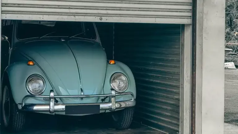 Classic car parked inside a garage with the garage door open